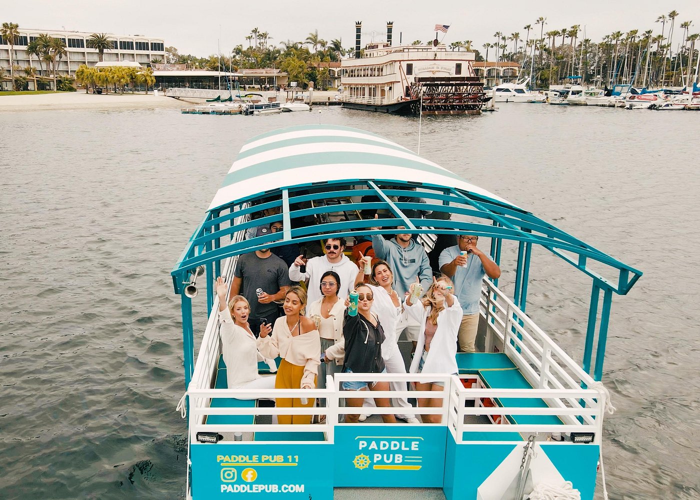 A group celebrating aboard a Paddle Pub boat on Mission Bay