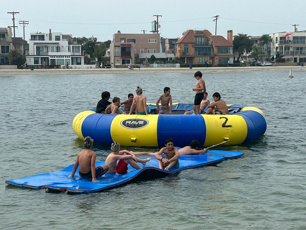 Kids playing on the Aqua Jump trampoline at Mission Bay Sportcenter birthday party watersports in San Diego