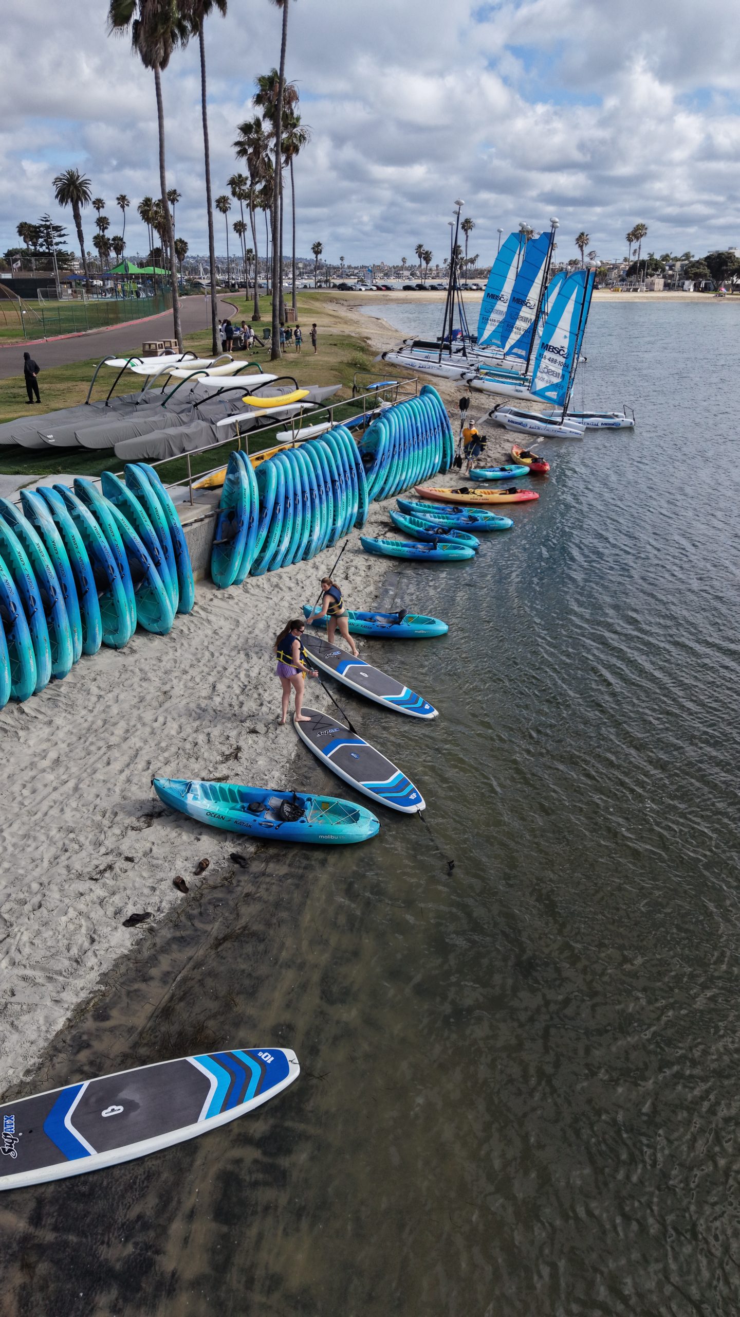 Paddleboards and kayaks on the beach at Mission Bay Sportcenter